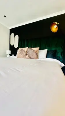 a white bed with two pillows on top of it at Hideaway Haven 2 in Cape Town