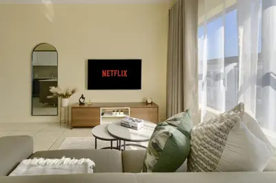 a living room with a couch and a table at Chic & Cozy Apartment with Pool, Gym & Balcony - The Sandown in Cape Town