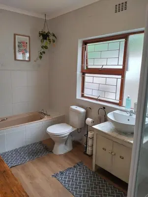 a bathroom with a tub and a toilet and a sink at Dawson78 in Hermanus