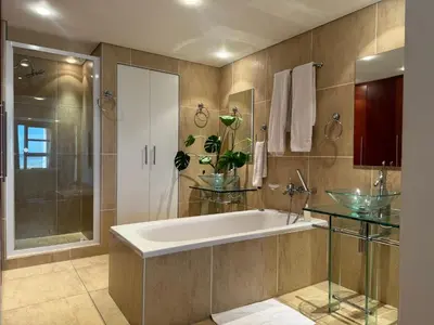 a bathroom with a large tub and a shower at Loddey's Self Catering Apartments - by Beach Collection in Strand