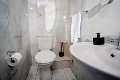 a white bathroom with a toilet and a sink at Boblodge in Cape Town