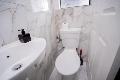 a white bathroom with a toilet and a sink at Boblodge in Cape Town