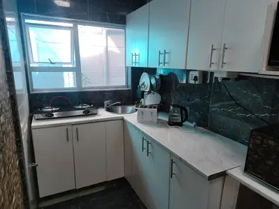 a kitchen with white cabinets and a sink and a window at Boblodge in Cape Town