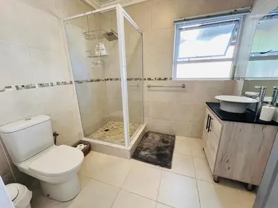 a bathroom with a shower and a toilet and a sink at Rissie's Place in Gordonʼs Bay