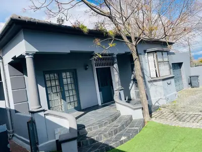 a blue and white house with stairs and a tree at ANNIKA B&B Claremont in Cape Town