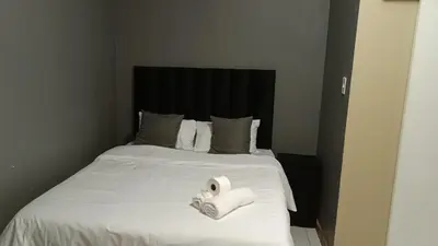 a bed with two rolls of toilet paper on it at Spring forth guest house in De Grendel