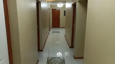 a hallway with a tile floor and a hallway with doors at Spring forth guest house in De Grendel