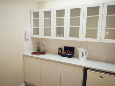 a kitchen counter with white cabinets and a sink at Zevenwacht Cottages in Kuilsrivier
