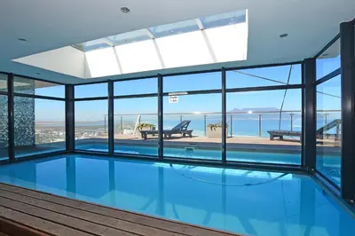 an indoor swimming pool with a view of the ocean at Aquarius 2 Bedroom Luxury Apartment in Cape Town