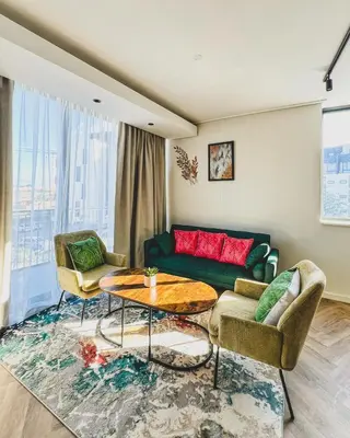 a living room with a couch and a table at Bethany Apartment ON PARK Century City in Cape Town