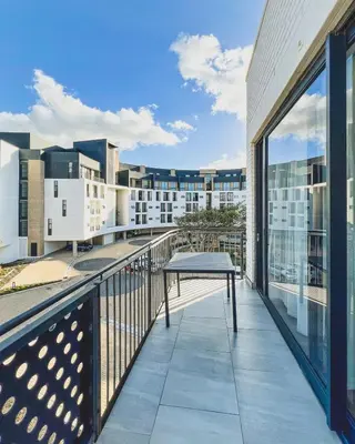 a balcony with a table and a view of a city at Bethany Apartment ON PARK Century City in Cape Town