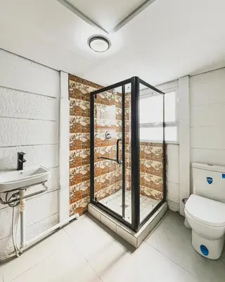 a bathroom with a shower and a toilet and a sink at Cedar Apartments on Century City in Cape Town