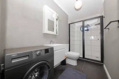 a washing machine in a bathroom with a toilet at Cape on Porterfield in Cape Town