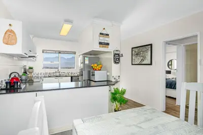 a kitchen with white appliances and a dining room at Odeon Towers 808 by Host Agents in Cape Town