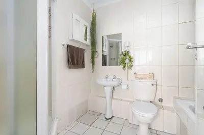 a white bathroom with a toilet and a sink at Odeon Towers 808 by Host Agents in Cape Town