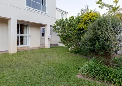a yard in front of a white house at Whale - a - While in Hermanus