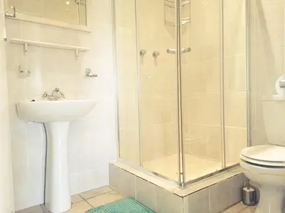 a bathroom with a shower and a sink and a toilet at Tyger Classique Self-Catering Cape Town, Tyger Valley in Bellville
