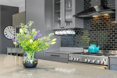 a kitchen with a vase of flowers on a table at Red River Valley in Rooiels