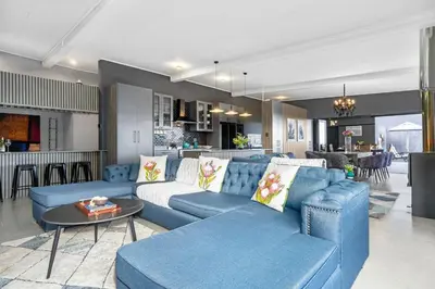 a living room with a blue couch and a table at Red River Valley in Rooiels