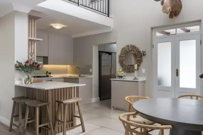a kitchen with a table and chairs and a dining room at Winelands Golf Lodges 2 in Stellenbosch