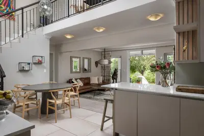 a kitchen and living room with a table and chairs at Winelands Golf Lodges 2 in Stellenbosch