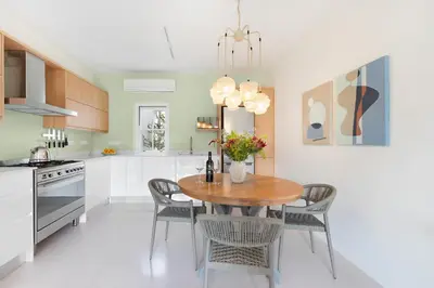 a kitchen with a wooden table and chairs at Winelands Golf Lodges 5 in Stellenbosch