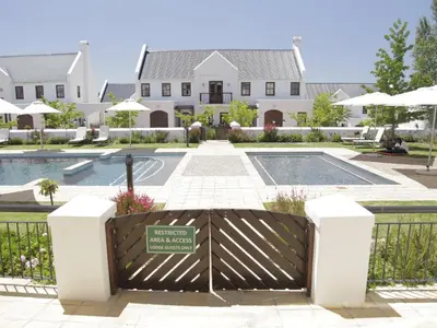 a gate in front of a house with a pool at Winelands Golf Lodges 5 in Stellenbosch