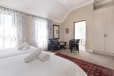 a bedroom with two beds and a large window at Winelands Golf Lodges 13 in Stellenbosch