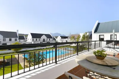 a balcony with a table and a view of a pool at Winelands Golf Lodges 20 in Stellenbosch