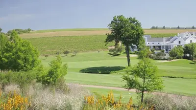 an aerial view of a golf course with a large house at Winelands Golf Lodges 20 in Stellenbosch