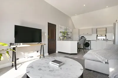a living room with a couch and a table with a tv at Winelands Golf Lodges 20 in Stellenbosch