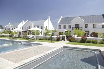 a house with a swimming pool in front of a house at Winelands Golf Lodges 22 in Stellenbosch