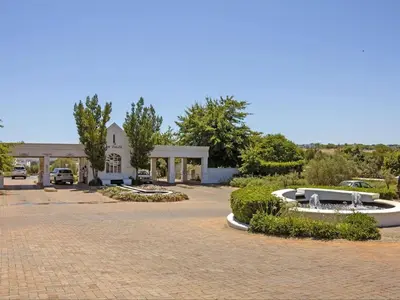 a building with a fountain in the middle of a driveway at Winelands Golf Lodges 33 in Stellenbosch