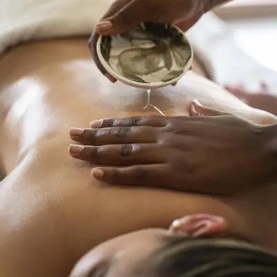 a woman getting a massage in front of a mirror at Winelands Golf Lodges 37 in Stellenbosch