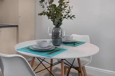a white table with a vase with a vase at Winelands Golf Lodges 40 in Stellenbosch