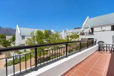a balcony with a view of a house at Winelands Golf Lodges 40 in Stellenbosch
