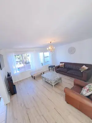 a living room with a couch and a table at Stunning 3 Bedroom beach house in Bloubergstrand in Cape Town