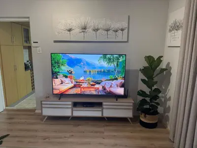 a flat screen tv sitting in a living room at Serene waterfront escape! Luxury, King bed! in Durbanville