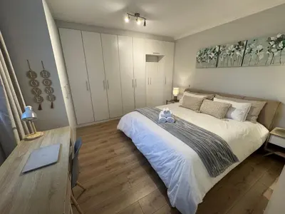 a bedroom with a large bed with a teddy bear on it at Serene waterfront escape! Luxury, King bed! in Durbanville