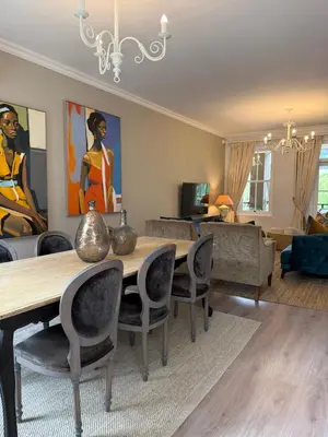 a living room with a wooden table and chairs at Franschoek Lermitage Villa 33 Three Bedroom Lake View in Franschhoek