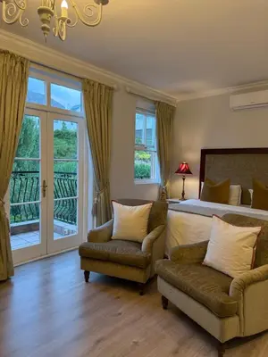 a bedroom with a bed and a couch and a chair at Franschoek Lermitage Villa 33 Three Bedroom Lake View in Franschhoek