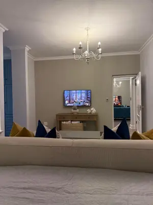 a living room with a couch and a tv at Franschoek Lermitage Villa 33 Three Bedroom Lake View in Franschhoek