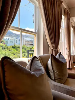 a couch with pillows in front of a window at Franschoek Lermitage Villa Two Bedroom Lake View in Franschhoek