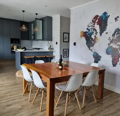 a dining room with a wooden table and white chairs at Scenic Mountain & Winelands views, Modern Design in Tygerberg Hills