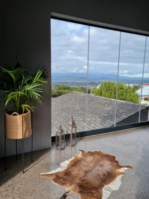 a room with a large window with a large tree stump on the floor at Scenic Mountain & Winelands views, Modern Design in Tygerberg Hills