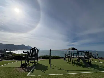 an empty playground with the ocean in the background at Hermanus Waterfront Boho Studio Apartment, Whale Coast Hideaway in Hermanus