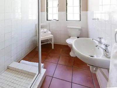 a white bathroom with a toilet and a sink at The Habit Apartments in Worcester