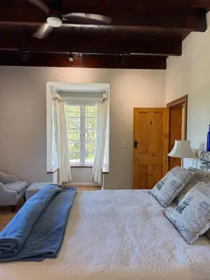 a bedroom with a large bed and a window at Sevilo Farmhouse in Stellenbosch