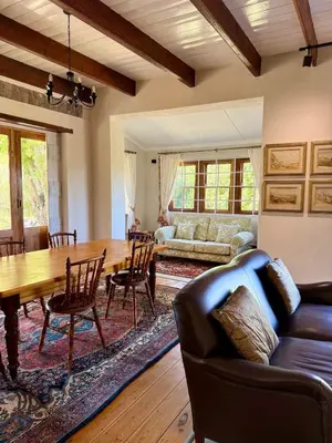 a living room with a wooden table and a couch at Sevilo Farmhouse in Stellenbosch