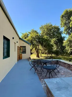 a patio with tables and chairs next to a building at Sevilo Farmhouse in Stellenbosch